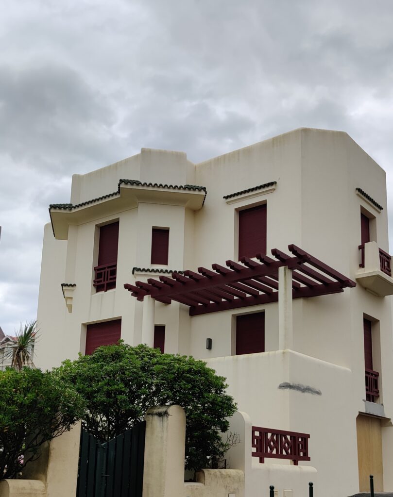 Stunning modern Basque-style house in Biarritz against a cloudy sky.